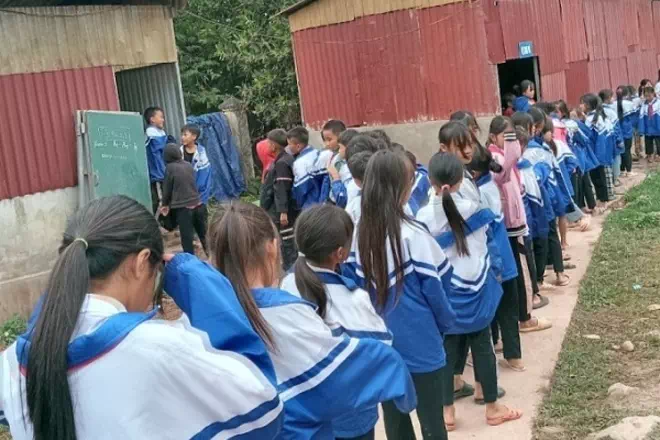 ベトナムの山岳地帯の学校で、トイレに行くために何十人もの列に並ぶ女子。